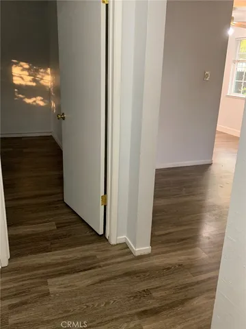 a view of a hallway with wooden floor and a floor to ceiling window