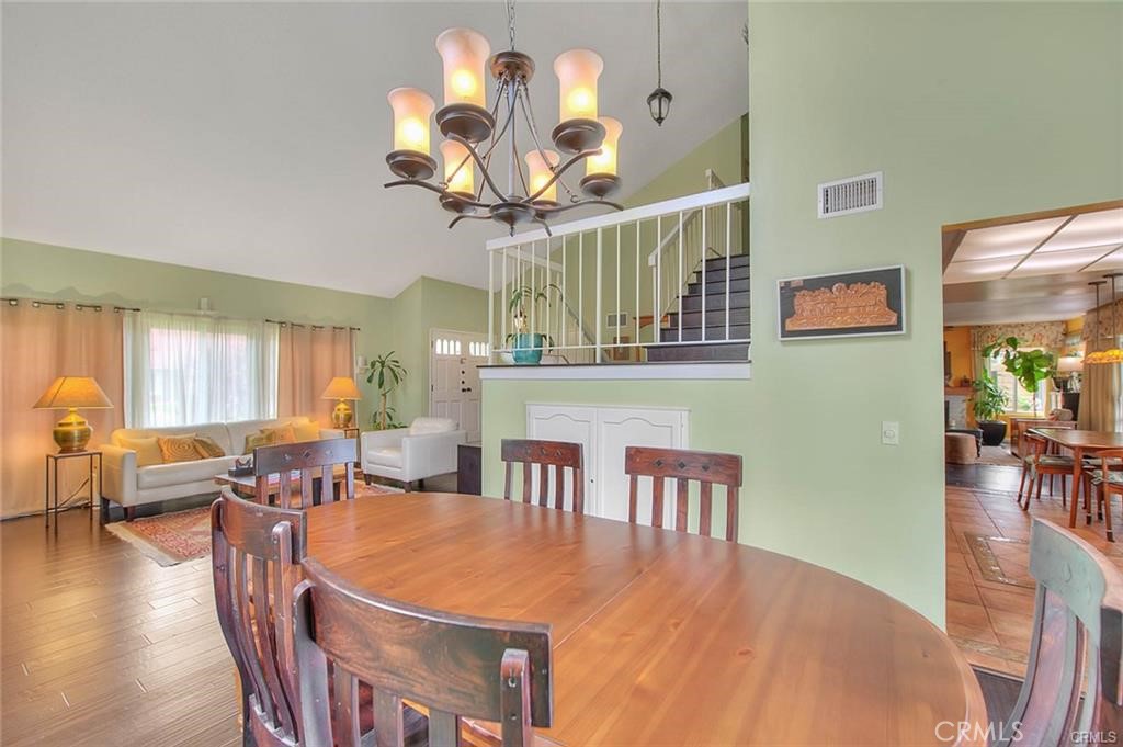 1449 Rolling Knoll Road Diamond Bar, CA 91765 - Photo 15 of 31 a dining room with wooden floor a chandelier a wooden table and chairs