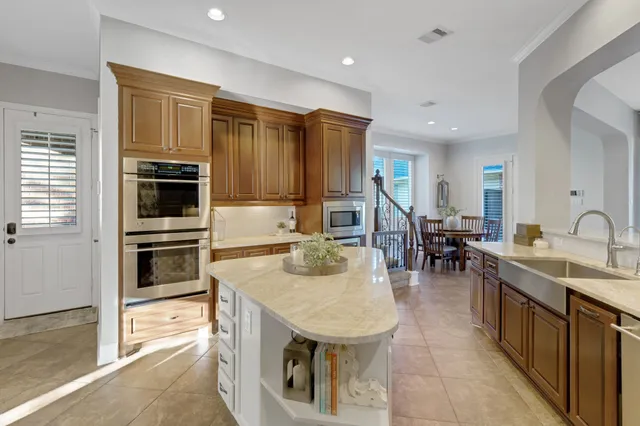 a large kitchen with kitchen island a large counter top space a sink stainless steel appliances and windows