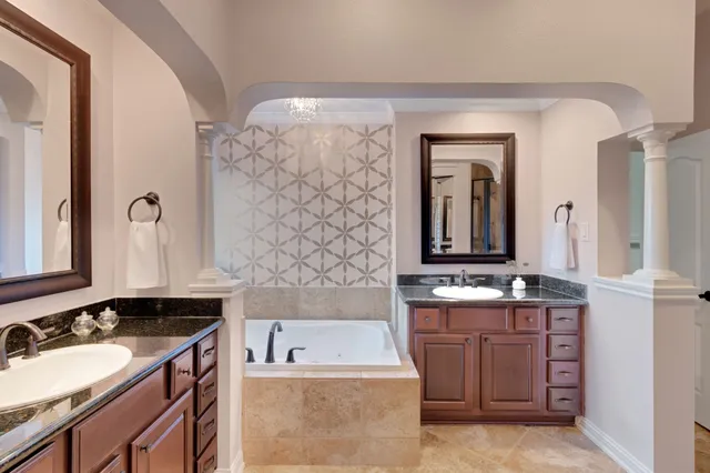 a large bed sitting in a bedroom next to a window and a chandelier