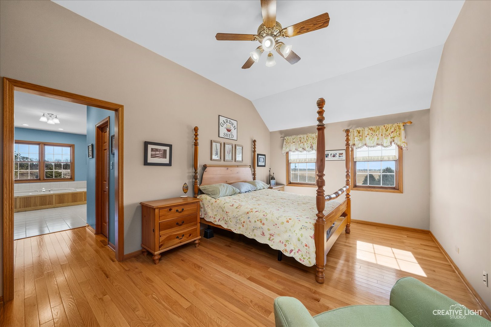 1651 Johnson Road Oswego, IL 60543 - Photo 19 of 60 a bedroom with a large bed a chandelier and windows