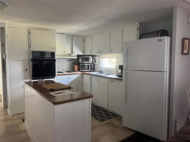 a kitchen with a refrigerator and a stove top oven