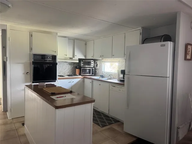 a kitchen with a refrigerator and a stove top oven