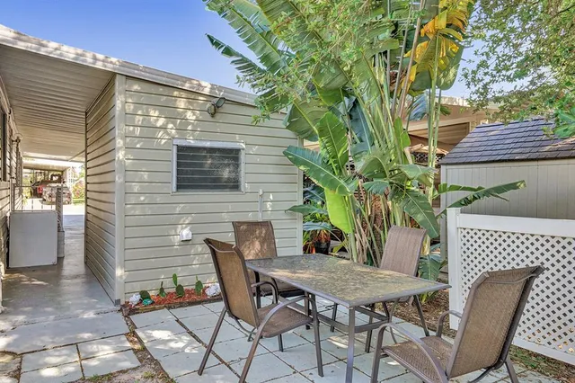 a backyard of a house with table and chairs