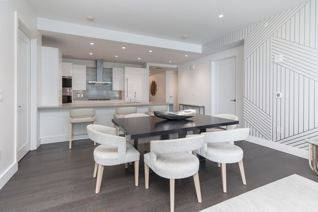 a kitchen with a dining table chairs and a dining table with wooden floor
