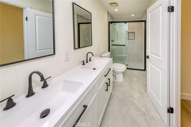 a bathroom with a double vanity sink mirror and toilet