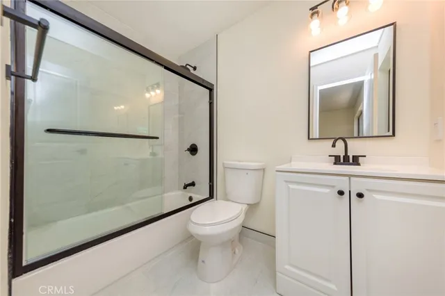 a bathroom with a sink a mirror a toilet and shower