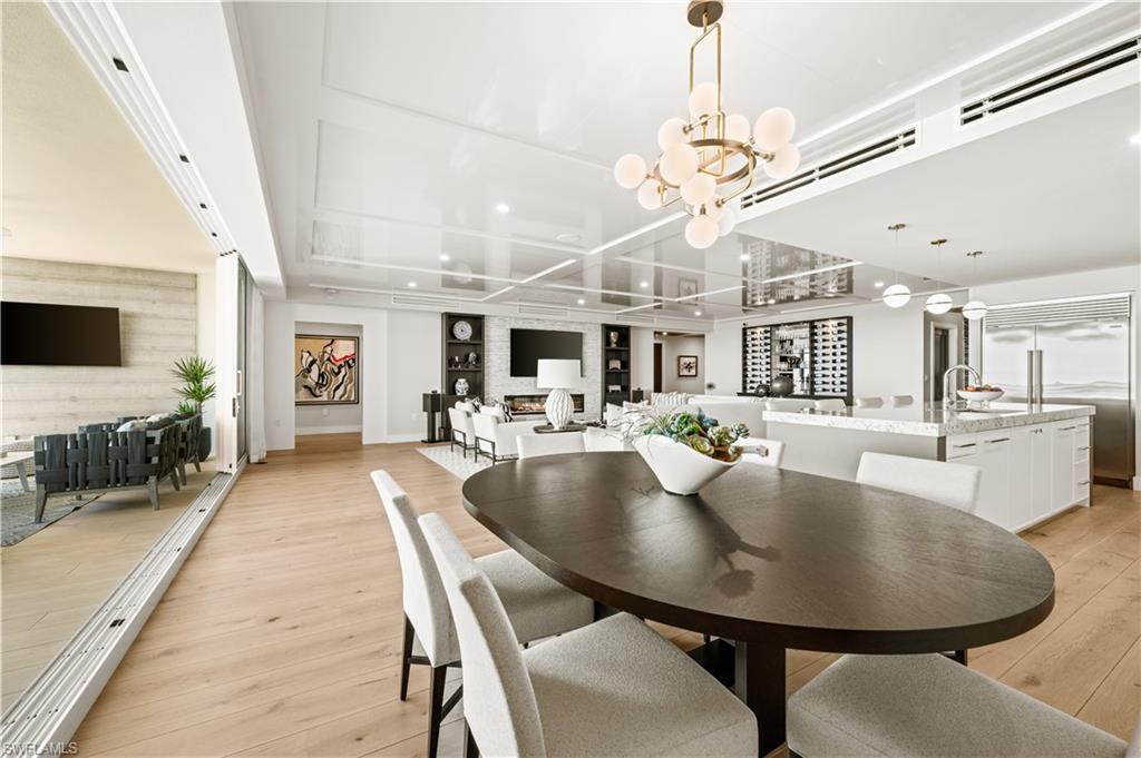 13925 Old Coast Road, Unit 1705 Naples, FL 34110 - Photo 25 of 42 Dining room with light wood finished floors and a chandelier