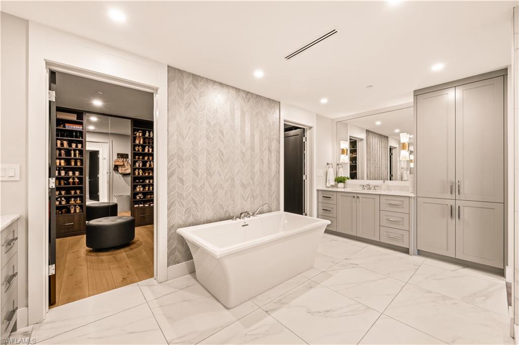 13925 Old Coast Road, Unit 1705 Naples, FL 34110 - Photo 6 of 42 Full bath with vanity, a freestanding bath, light marble finish floors, recessed lighting, and wallpapered walls