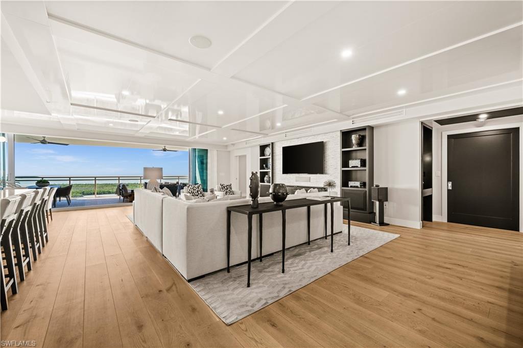 13925 Old Coast Road, Unit 1705 Naples, FL 34110 - Photo 7 of 42 Living room with light wood-style flooring, floor to ceiling windows, and a ceiling fan