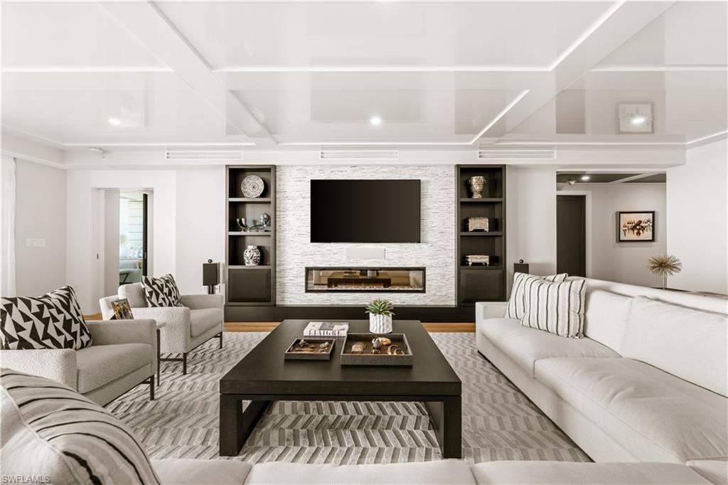 13925 Old Coast Road, Unit 1705 Naples, FL 34110 - Photo 8 of 42 Living area with a fireplace and wood finished floors