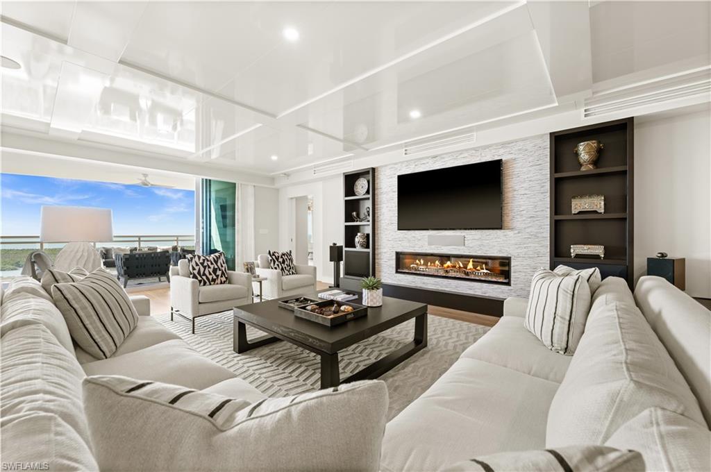 13925 Old Coast Road, Unit 1705 Naples, FL 34110 - Photo 9 of 42 Living area featuring built in shelves, wood finished floors, a fireplace, and recessed lighting