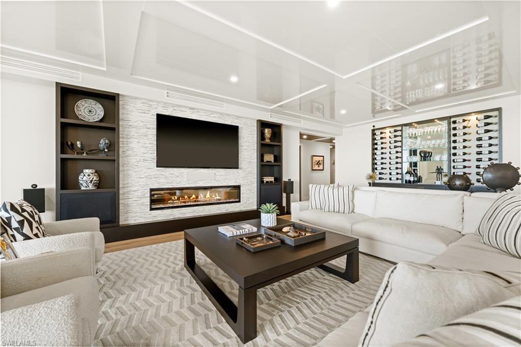 13925 Old Coast Road, Unit 1705 Naples, FL 34110 - Photo 10 of 42 Living room featuring a fireplace, built in shelves, and wood finished floors