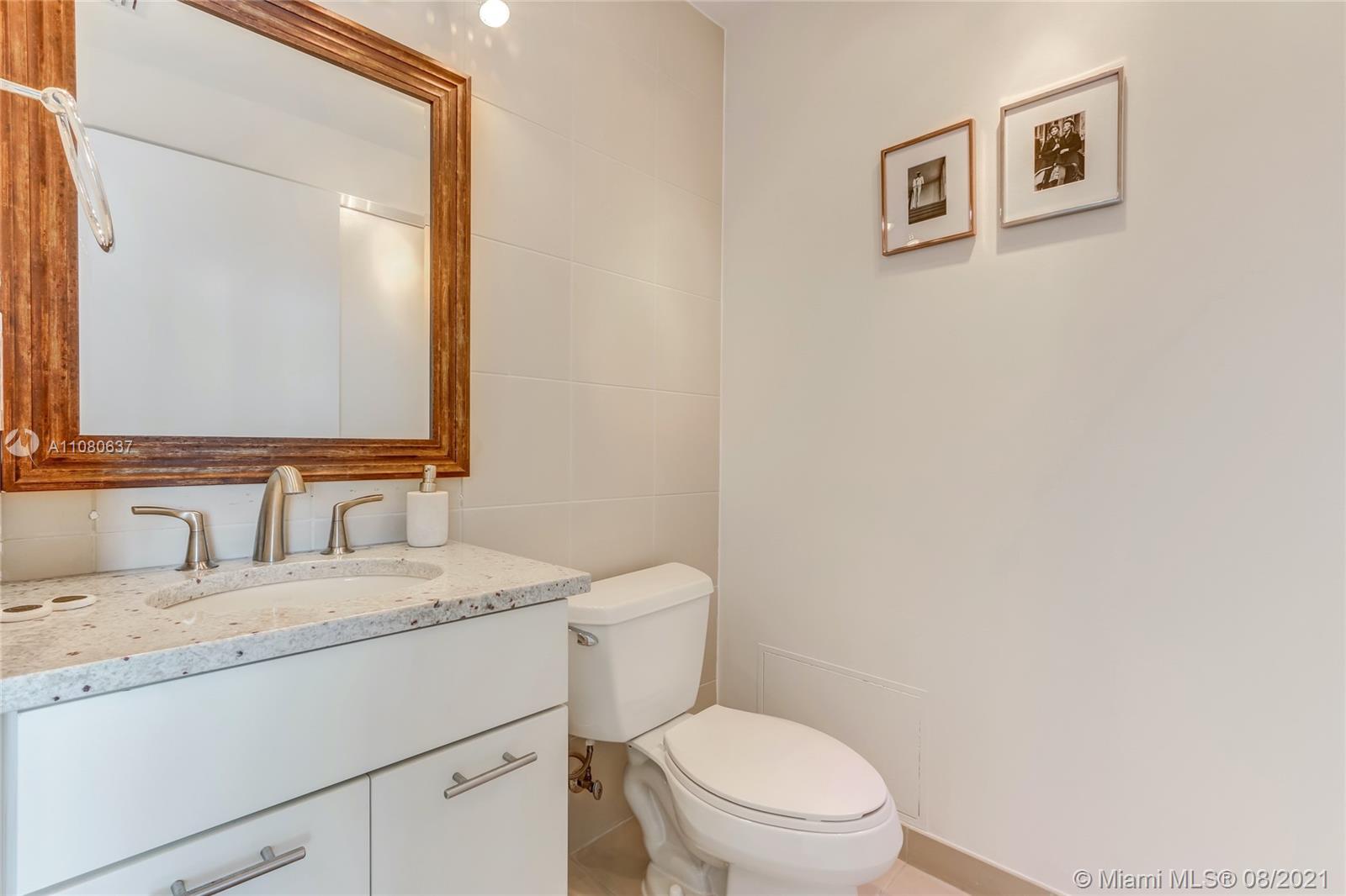 2889 McFarlane Road, Unit 2114 Coconut Grove, FL 33133 - Photo 14 of 15 a bathroom with a granite countertop toilet sink and mirror