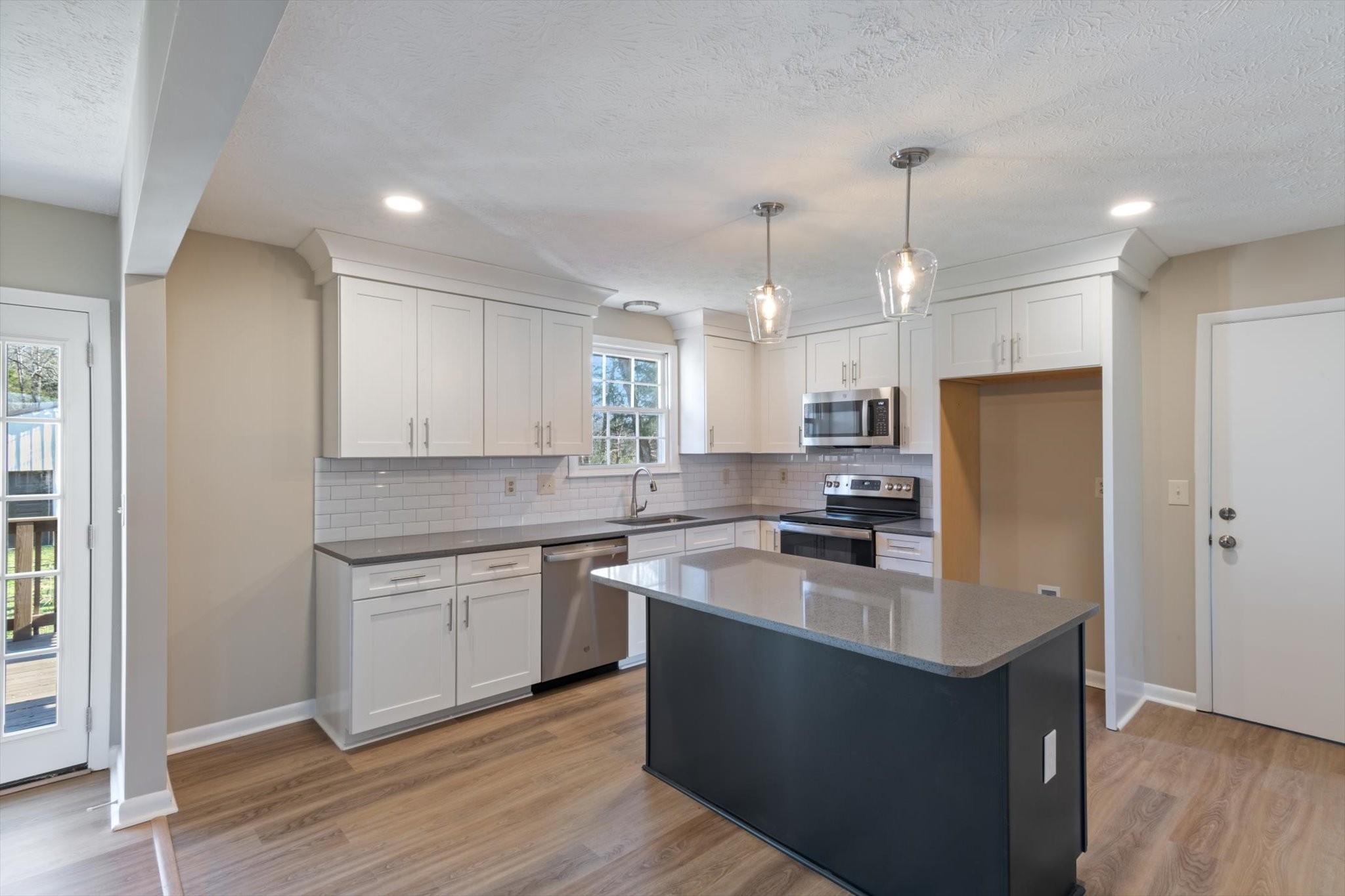 7956 Lebanon Road Murfreesboro, TN 37129 - Photo 11 of 24 a kitchen with stainless steel appliances granite countertop a sink a stove a refrigerator and island with wooden floor