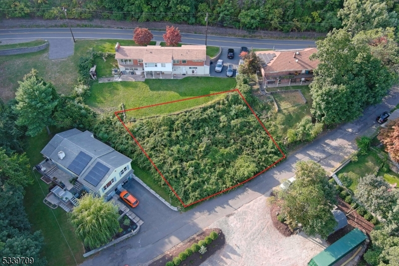 an aerial view of a house with a garden and lake view