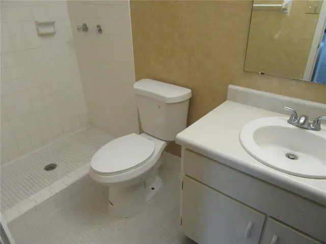 a white toilet sitting next to a bath tub