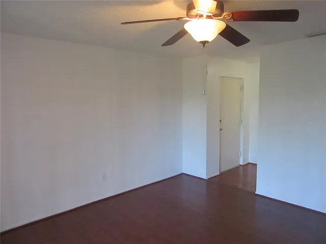 en empty room with wooden floor fan and window