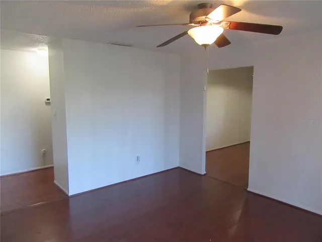 an empty room with a fan and a fan