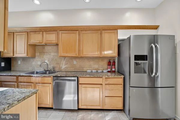 a kitchen with stainless steel appliances granite countertop a refrigerator sink and cabinets