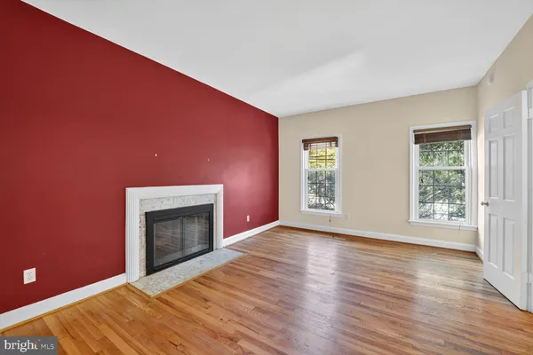 an empty room with windows and fireplace