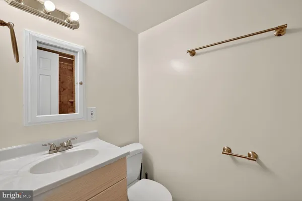 a bathroom with a sink mirror and a toilet