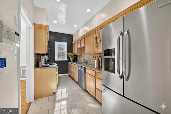 a kitchen with stainless steel appliances a refrigerator sink and cabinets