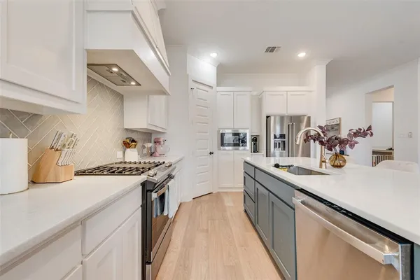 a kitchen with a sink a stove and cabinets