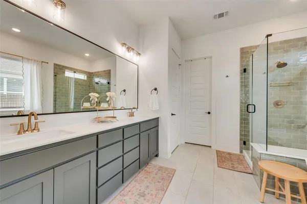 a bathroom with a double vanity sink mirror and shower