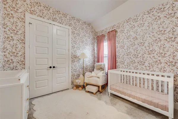 a spacious bedroom with a bed and a chair