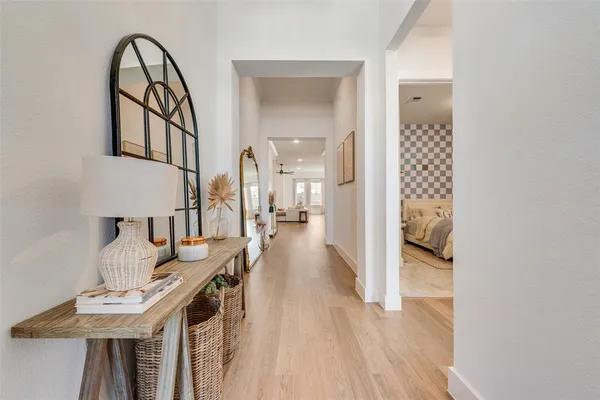 a view of a hallway with wooden floor and dining table