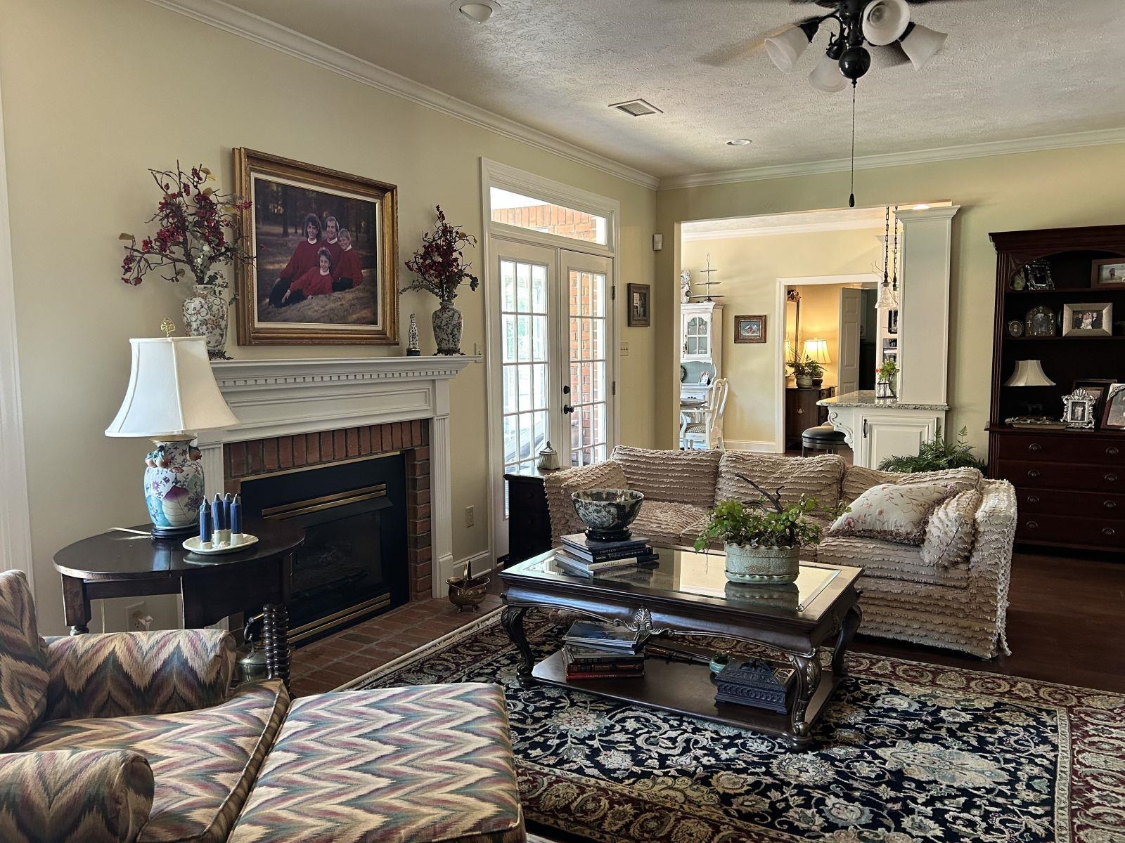 110 Eagle Trace Road Covington, TN 38019 - Photo 8 of 10 Living room with a textured ceiling, ceiling fan, a fireplace, and crown molding