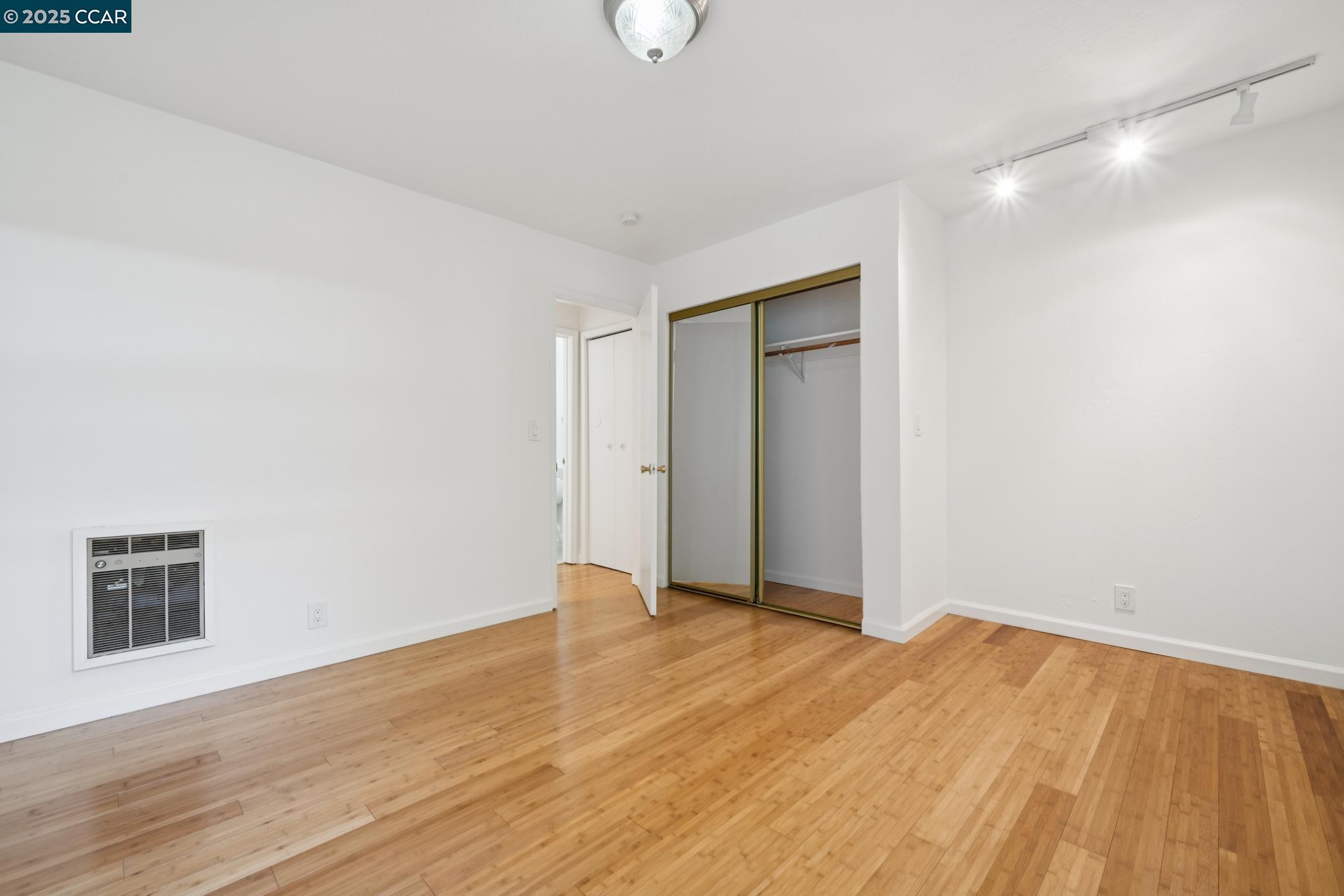 150 Pearl Street, Unit 122 Oakland, CA 94611 - Photo 13 of 34 a view of an empty room with wooden floor and a window