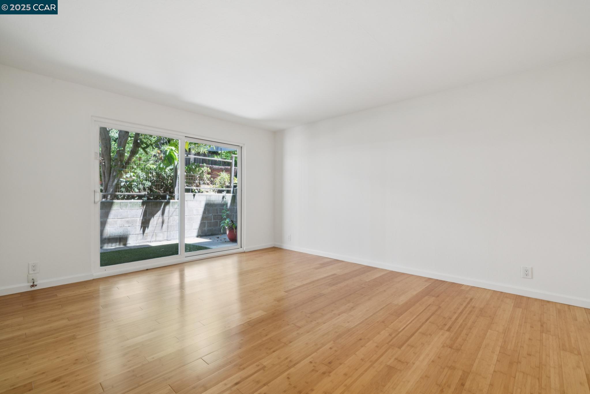 150 Pearl Street, Unit 122 Oakland, CA 94611 - Photo 4 of 34 a view of an empty room with wooden floor and a window