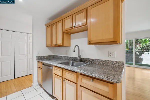 a kitchen with granite countertop a sink and cabinets