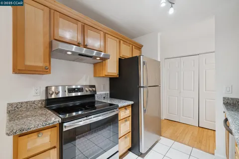 a kitchen with stainless steel appliances granite countertop a refrigerator and a stove