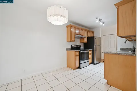 a kitchen with a refrigerator and a stove top oven