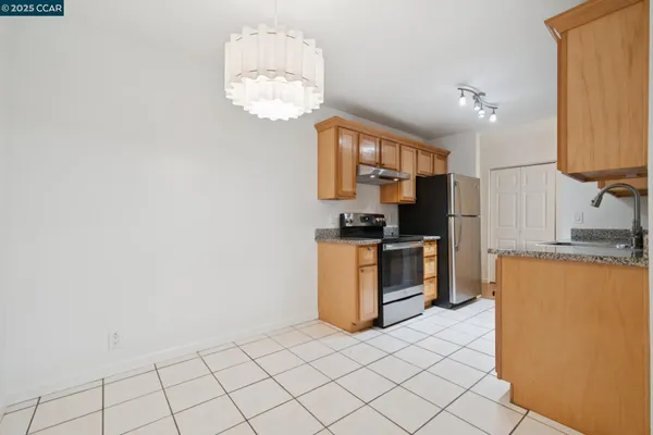 a kitchen with a refrigerator and a stove top oven