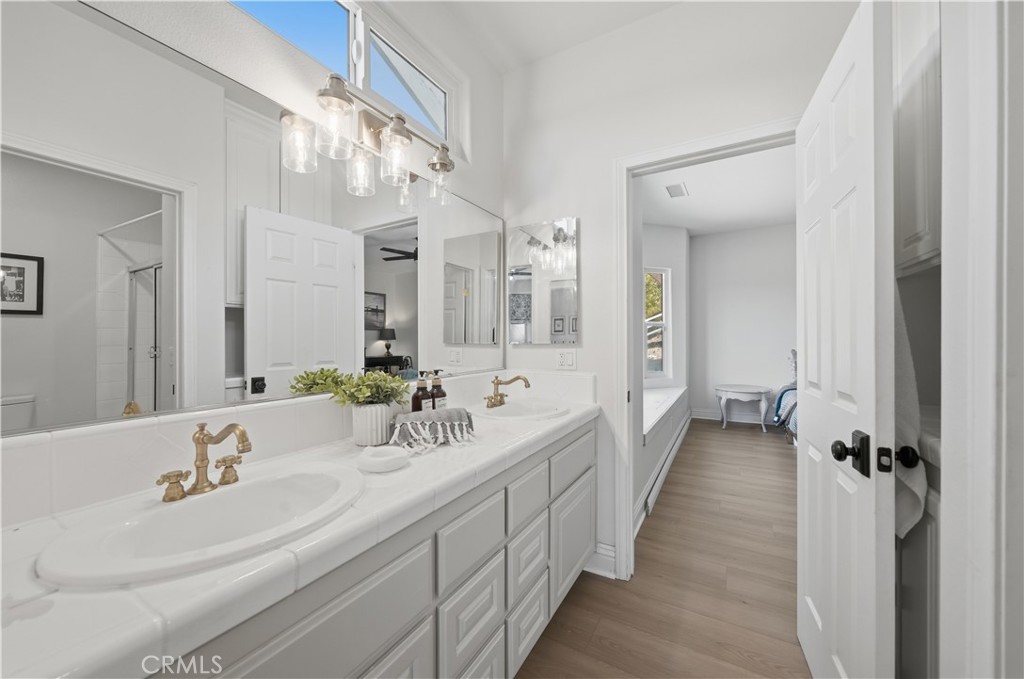 41110 Los Ranchos Circle Temecula, CA 92592 - Photo 41 of 77 a bathroom with double vanity sinks a large mirror and shower
