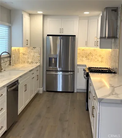 a kitchen with granite countertop a refrigerator and a sink