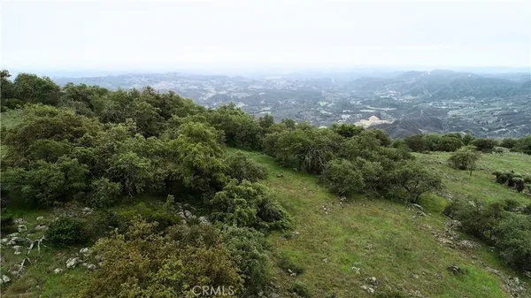 an aerial view of house with yard and mountain view in back