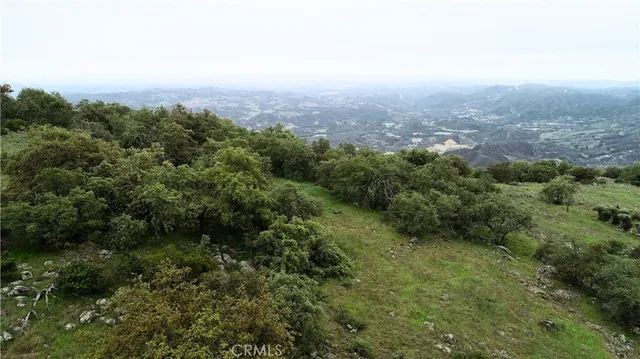 an aerial view of house with yard and mountain view in back
