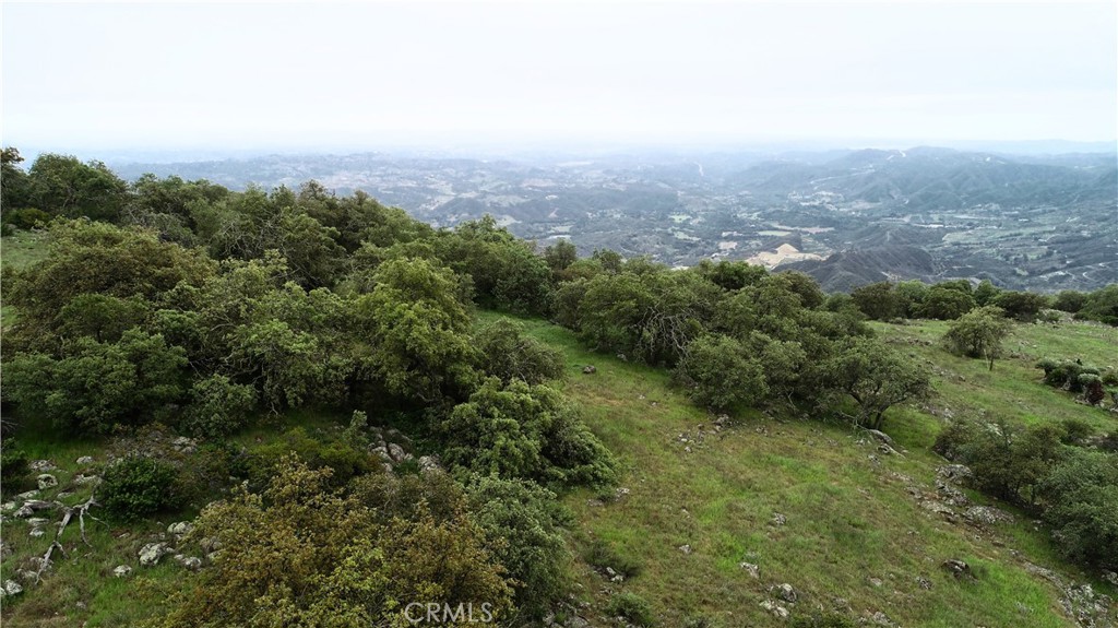 an aerial view of house with yard and mountain view in back