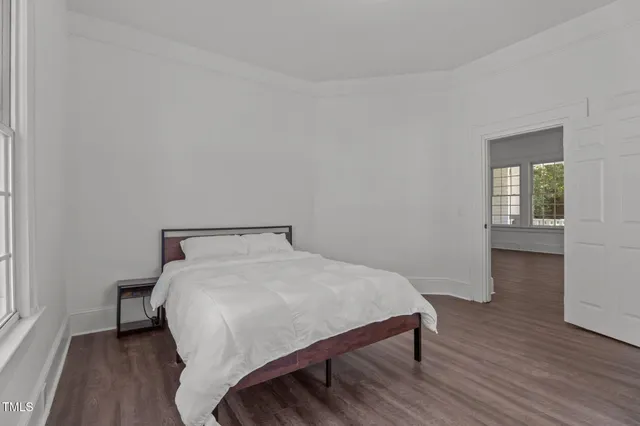 a large bed sitting in a bedroom next to a window