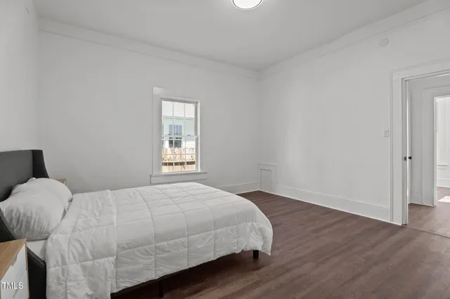 a bedroom with a bed and wooden floor