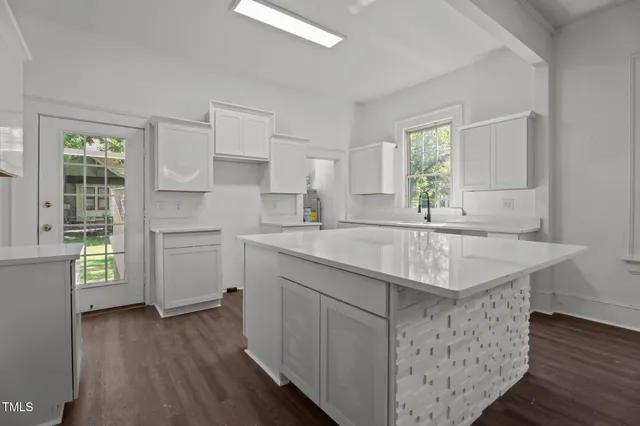 a kitchen with a sink dishwasher a stove and a refrigerator with wooden floor