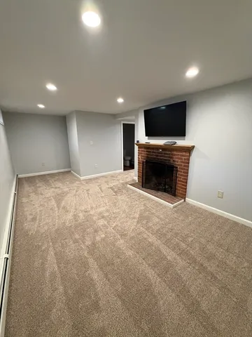 an empty room with a flat screen tv and a fireplace