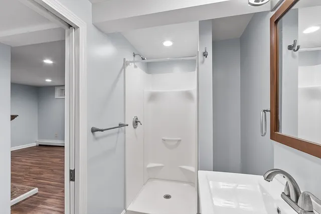 a bathroom with a sink a toilet and shower