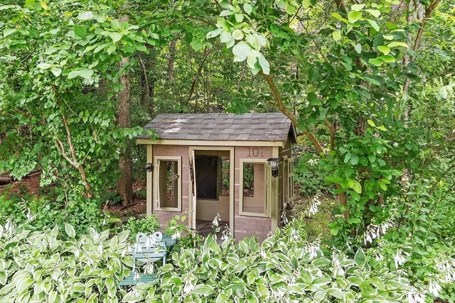 a view of a house with potted plants and large tree