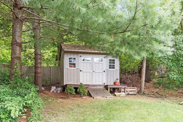 a view of a chair and table in backyard of the house